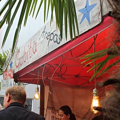 CUBITA-Schild am Stand — Arepas-Schriftzug mit blauem Stern und Palmblatt im Vordergrund