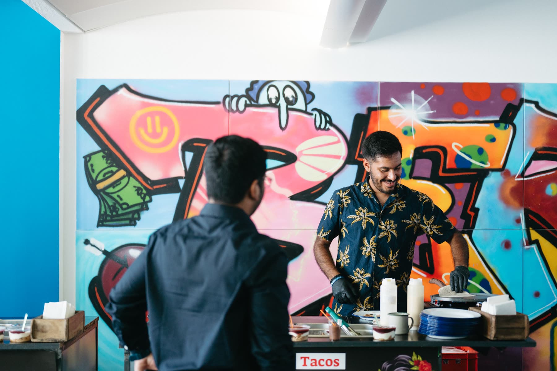 Hausmessen-Catering: Ricky bedient einen Gast am Tacos-Stand bei einer Firmen-Hausmesse