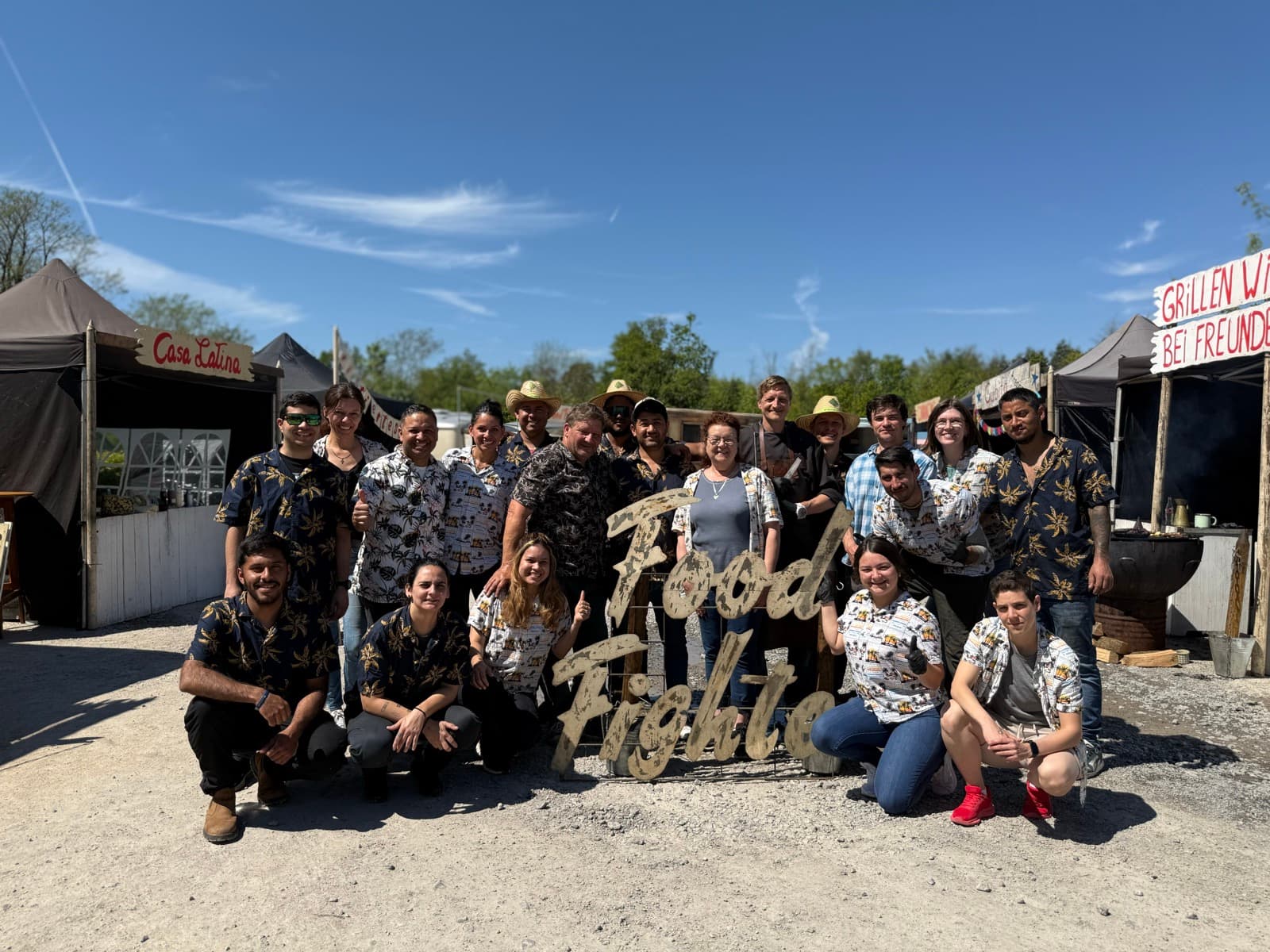 Das FoodFighter-Catering-Team auf einem Event — Gruppenbild vor den Ständen Casa Latina und Grillen wie bei Freunden